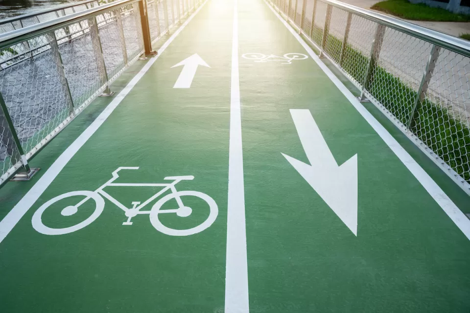 Green painted two-way bike lane with bike symbols and arrows.